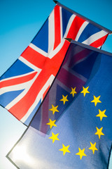 European Union and British Union Jack flag flying together in front of bright blue sky as the UK...