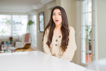 Young beautiful woman at home afraid and shocked with surprise expression, fear and excited face.