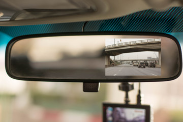 Close up car on highway at sunset, with video recorder next to a rear view mirror,video recorder...