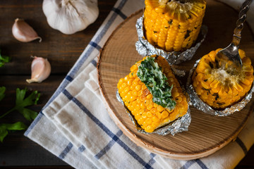 Baked corn with spiced butter on a rustic wooden background. Barbecue food. Thanksgiving Day. Autumn harvest.