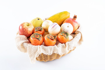 Rattan basket with fresh fruits on a white background