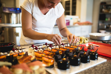 Young woman decorating raspberry cookies,stock photo