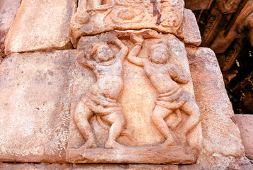 Ancient artwork with dancing people on wall of the 7th century temple of Pattadakal, India. Hindu architecture decoration
