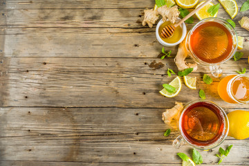 Autumn tea with mint and lemon with ingredients - fresh mint leaves, sliced lemon and honey, rustic wooden background copy space