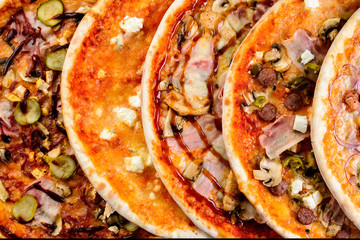 variety of mini pizzas from above on wooden table with blank space