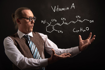 Professor presenting handdrawn chemical formula of Vitamin A