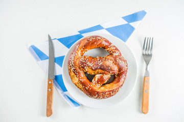 Oktoberfest festive cutlery set  with with a traditional checkered  tablecloth, plate, pretzel, fork, knife and a glass of beer. background for Restoration menu