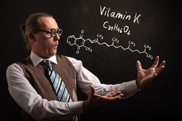 Professor presenting handdrawn chemical formula of Vitamin K