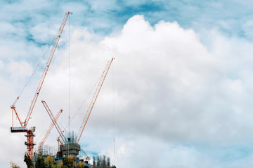 Building construction of modern real estate home with tower cranes under construction working site...