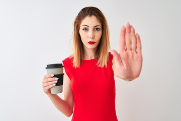 Young beautiful redhead woman drinking take away coffee over isolated white background with open hand doing stop sign with serious and confident expression, defense gesture