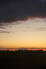 Colorful dramatic sky with cloud at sunset over fields and forest near Kyiv, Ukraine. View from plane. Sunset rays of the sun