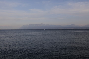 Far boats on a lake with mountains 