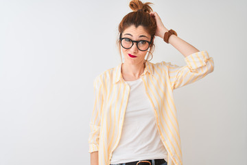 Redhead woman wearing striped shirt and glasses standing over isolated white background confuse and...