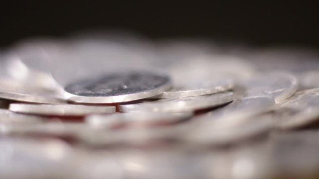 Extreme Close Up Of Rotating Aluminum Coins On Black Background.