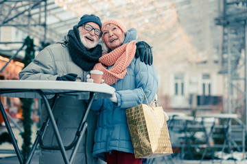 Happy pensioners drinking coffee after going shopping on Christmas day