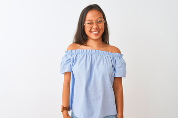 Young chinese woman wearing blue t-shirt and glasses over isolated white background winking looking...