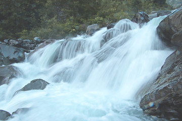 Fototapeta premium Rabi River flowing with speed with mountain rocks in the background 