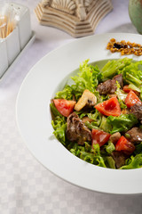 Warm salad with tomato and roasted meat, healthy food