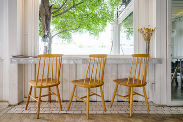 Wooden chairs with marble bar and tree on outside