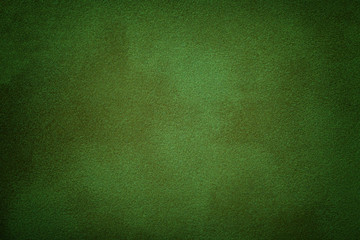 Dark green matte background of suede fabric, closeup.