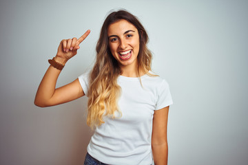 Young beautiful woman wearing casual white t-shirt over isolated background Smiling pointing to head with one finger, great idea or thought, good memory