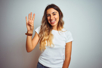 Obraz na płótnie Canvas Young beautiful woman wearing casual white t-shirt over isolated background showing and pointing up with fingers number four while smiling confident and happy.