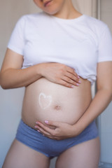 Pregnant woman touching her belly with hands