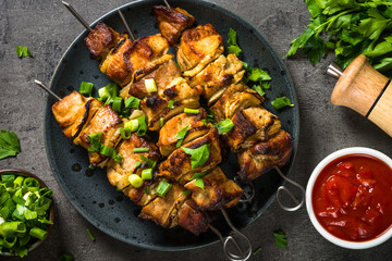 Grilled meat with herbs on black top view.