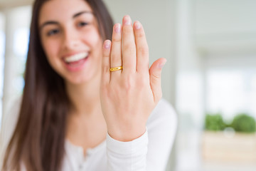 Fototapeta premium Beautiful young woman showing hand wearing wedding alliance ring