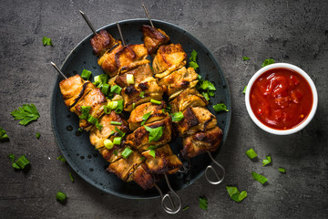 Grilled meat with herbs on black top view.