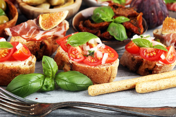 Italian antipasti wine snacks set. Cheese variety, Mediterranean olives, Prosciutto di Parma, tomatoes, artichokes