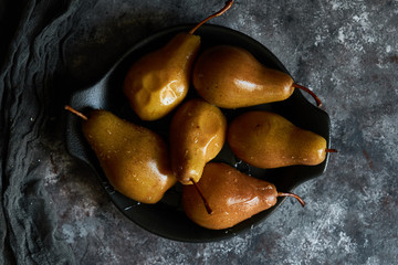 Honey poured baked pears in a plate Dark photo