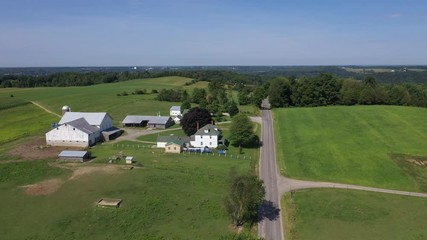 Aerial Ohio Amish four horse team fertilizing crops. Settled late 1700's as pioneer religious settlement. Old Amish Mennonite town. Rural farming landscape. Mechanical horse driven equipment.