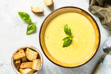 Zucchini Cream soup with basil and croutons on white.
