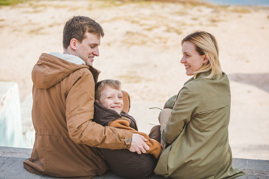 young beautiful family sitting at beach with view lake