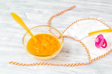 baby food - carrot puree on wooden background