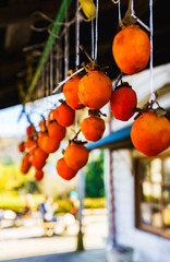 日本の秋のイメージ：日本の田舎の風物詩である軒先に吊された干し柿のオレンジ色のカーテン