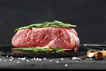 Steak raw. Barbecue Rib Eye Steak or rump steak on dark rustic table