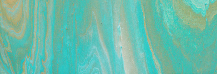 photography of abstract marbleized effect background. turquoise, gold, blue and white creative colors. Beautiful paint. banner