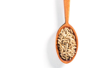 Cumin seeds (Cuminum), Jeera in wooden spoon on a white background vertically