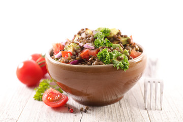 bowl of lentils salad with tomato, onion and cucumber