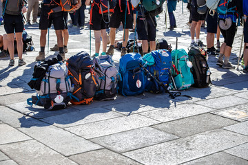 Group of Pilgrim backpack in a row on paving stone of Obradoiro square, Santiago de Compostela, Spain - obrazy, fototapety, plakaty