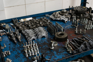 Machine engine components Engine Parts, nuts, bolts,  bearings and differential stars lie on the table close-up