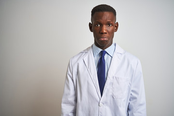 Young african american doctor man wearing coat standing over isolated white background depressed and worry for distress, crying angry and afraid. Sad expression.