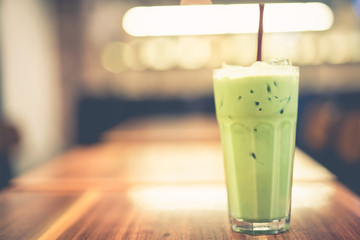 local business and relaxation activity from ice green tea put on wooden table in vintage coffee shop with softfocus background