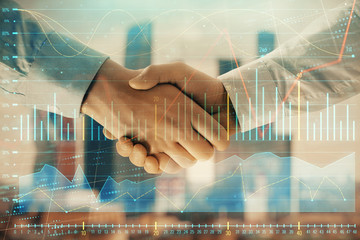 Double exposure of financial graph on cityscape background with two businessman handshake. Concept of stock market deal