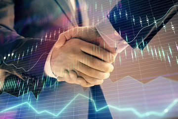 Multi exposure of forex graph on abstract background with two businessmen handshake. Concept of success on stock market