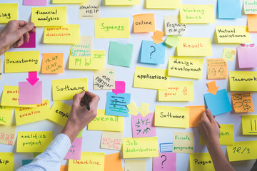 Business people write down an important note, using on the paper stickers post. Brainstorming, teamwork. 