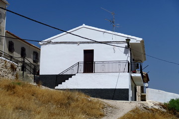 Maison peinte en noir et blanc. Ciel bleu.