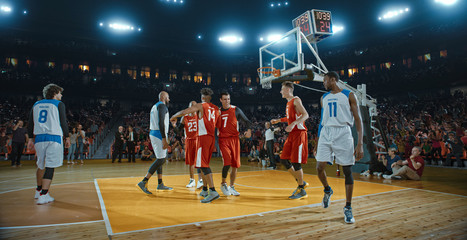 Basketball players on big professional arena during the game. Tense moment of the game. Celebration